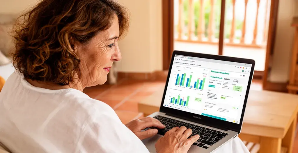 Usuario consultando herramienta de valoración inmobiliaria en ordenador portátil